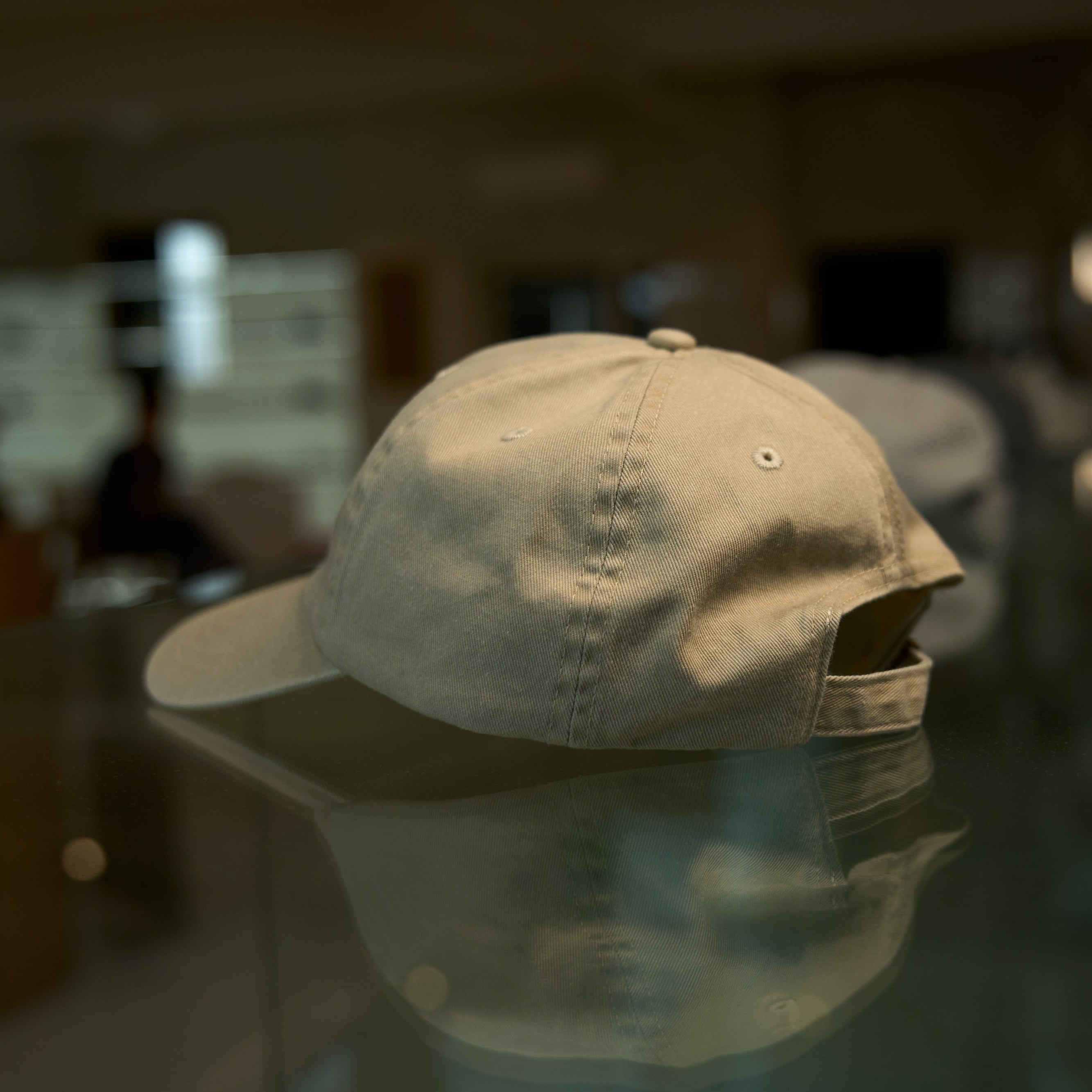 Beige cap on a glass table with a blurred indoor background