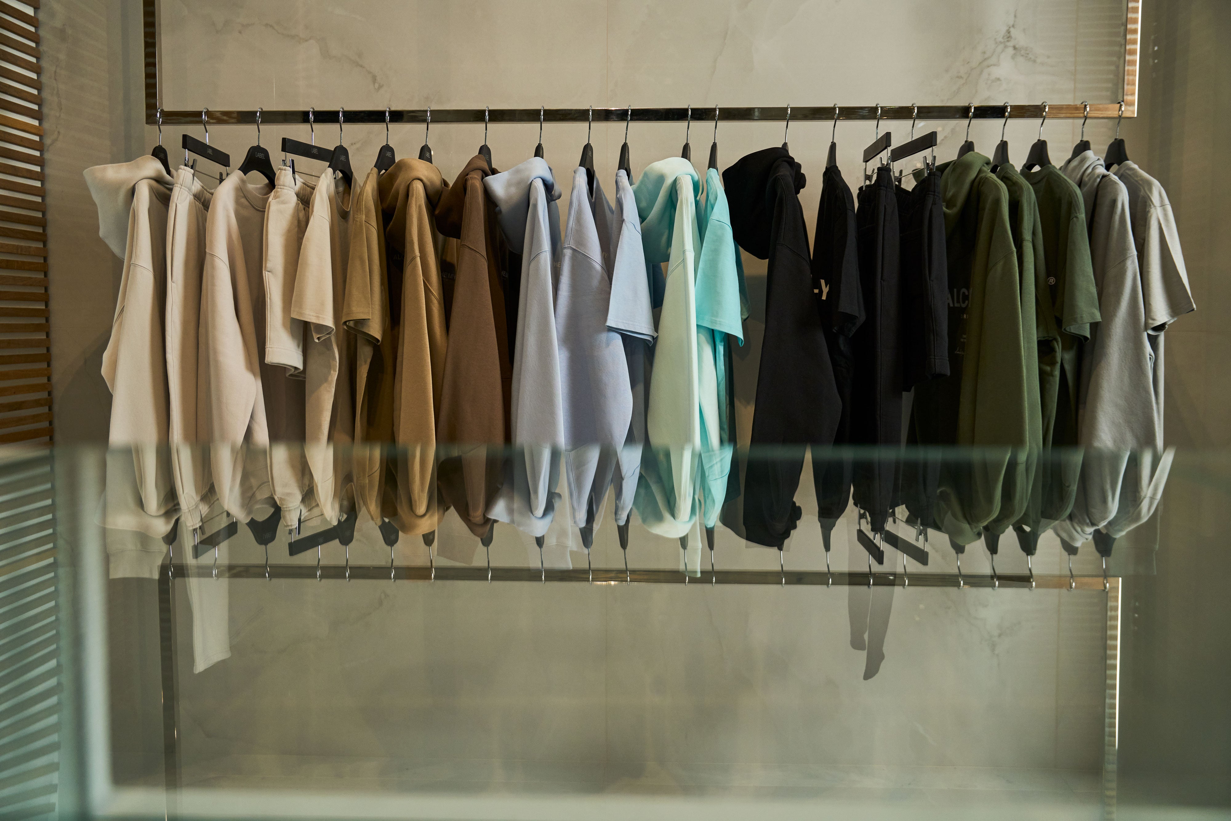Row of hanging clothes on a rack with a neutral background