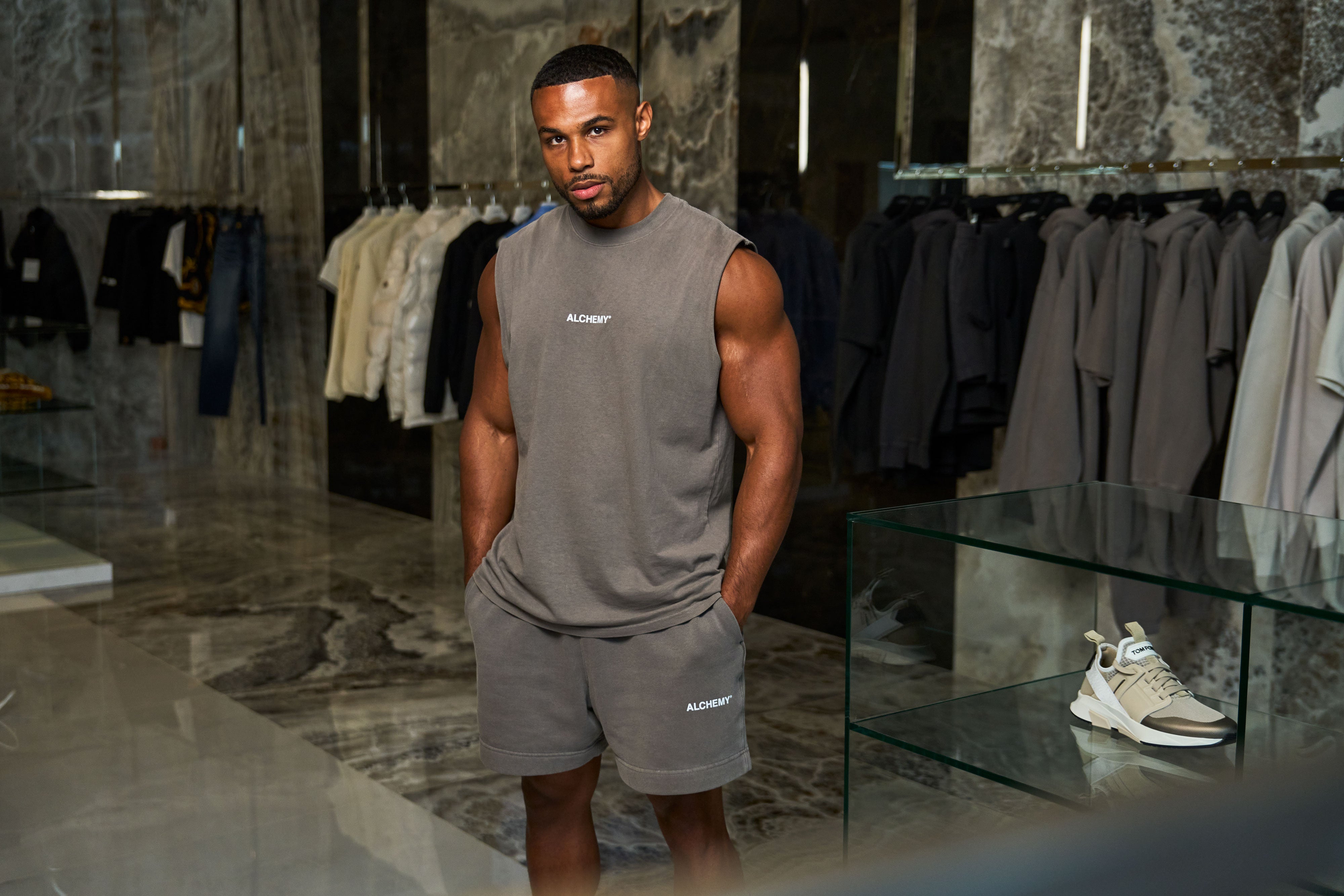 Man wearing a gray sleeveless shirt and shorts in a clothing store
