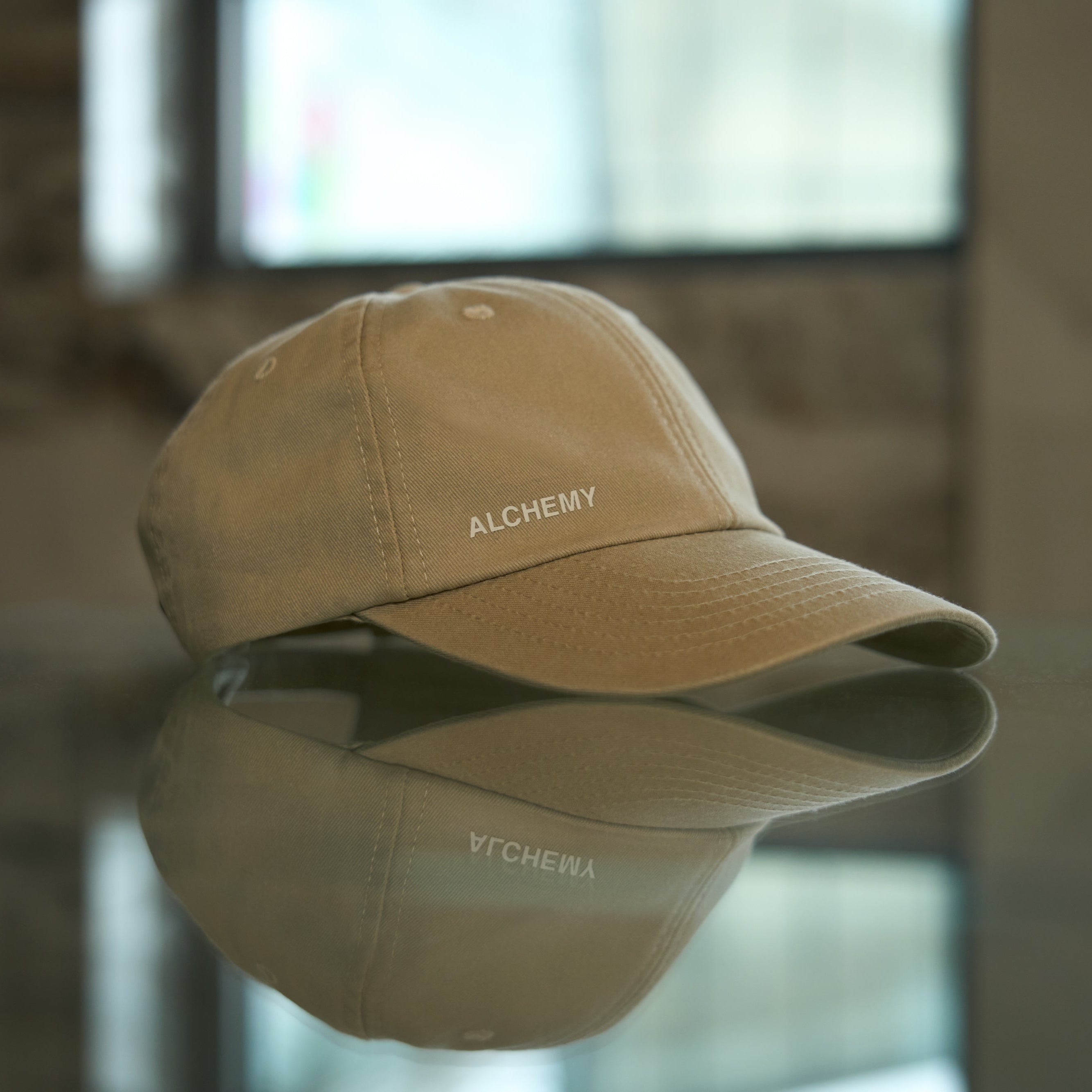 Bone cap with 'ALCHEMY' branding on a reflective surface